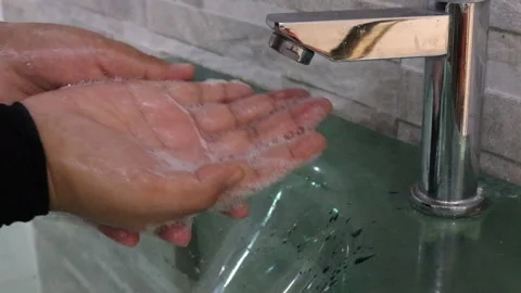 Washing hands with soap at sink Video stock 136934616