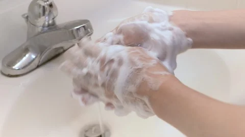 Washing hands with soap in sink with running water and faucet Stock Footage