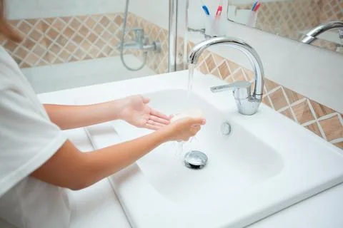 Washing hands with soap under the tap with water. The child washes his hands Stock Photos