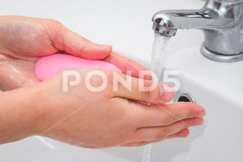 Washing hands under the faucet with soap Stock Photos