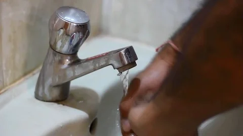 Washing hands under an old running tap in bathroom and then closing it. Stock Footage 123431599