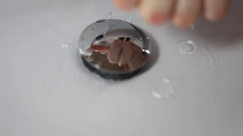 Washing hands under running water over shiny sink drain splash and motion reflec Stock Footage 309334032