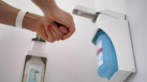 Washing Hands Using Hand Sanitizer In Hospital to Disinfect Virus Stock Footage 128839903