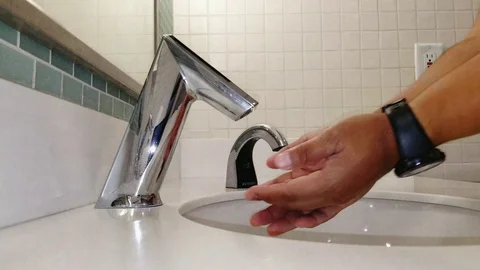 Washing hands using a touchless water faucet on a sink Stock Footage 115498297