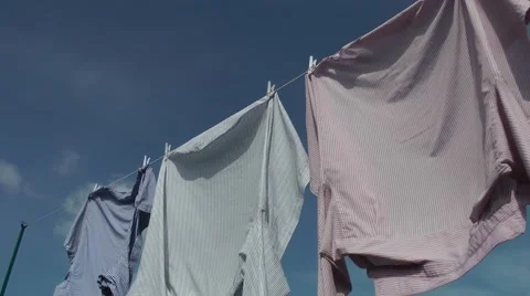 Washing line shirts stripes deep blue sky clouds pegs Stock Footage 48972078