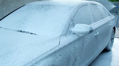 Washing luxury silver car on touchless car wash. Washing sedan car with foam Stock Footage 261494604