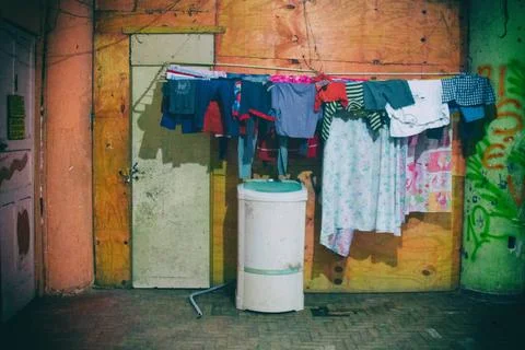Washing machine and bed sheets and clothes hanged to dry on the outside of... Stock Photos
