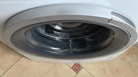 Washing machine cleaning clothes in home laundry room during afternoon wash Stock Footage 328409367