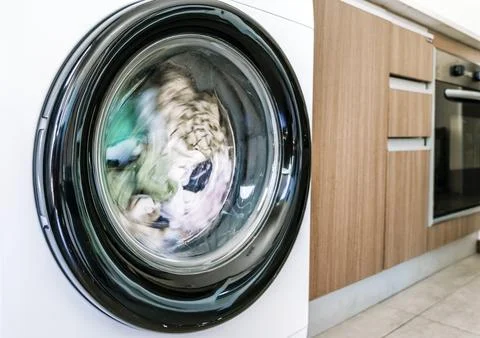 Washing machine with clothes in interior of the laundry room at home. Housework Stock Photos
