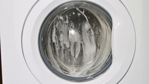 Washing machine door with rotating garments inside. Stock Footage 123442711