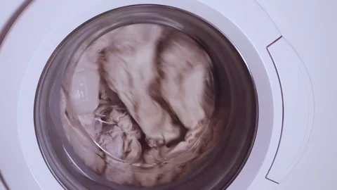Washing machine door with rotating garments inside Stock Footage 233022270