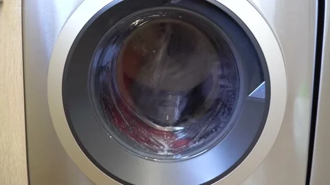 The washing machine draws in water and starts the wash cycle. Stock Footage 149577093