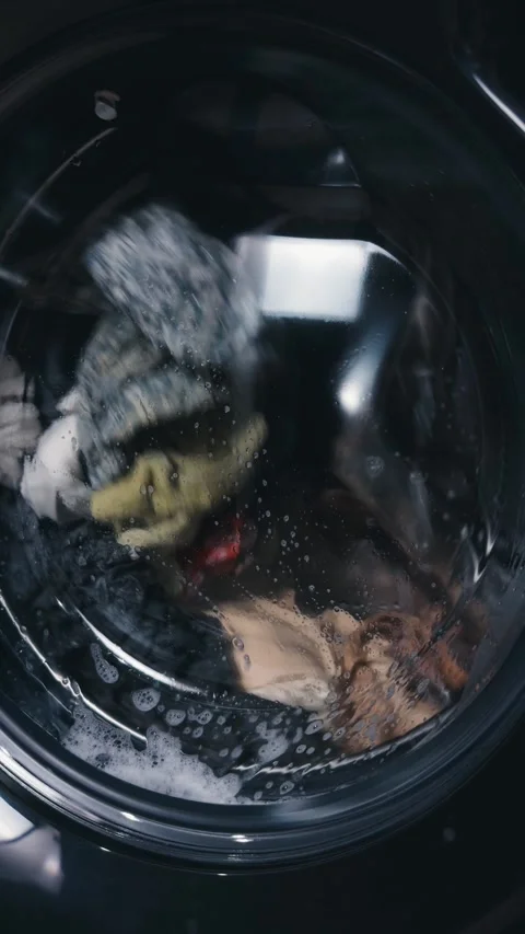 Washing machine drum spinning, cleaning dirty laundry with water and detergent, Vídeo Stock 344911462