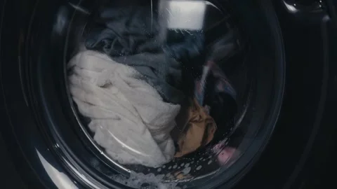 Washing machine drum spinning, cleaning clothes with water and detergent during Stock Footage 344911785