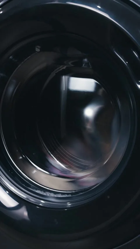 Washing machine drum spinning, washing colorful clothes during laundry cycle, Vídeo Stock 344911545