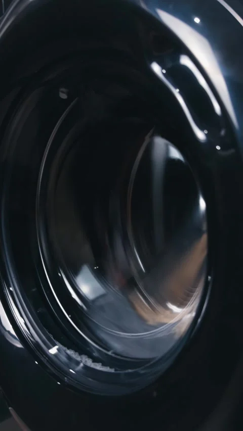 Washing machine drum spinning with water, indicating cleaning cycle and laundry Vídeo Stock 344911557