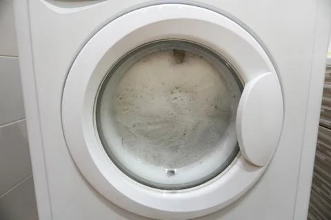 Washing machine with foam inside, view through glass door Stock Photos