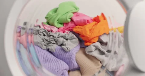 Washing machine full of multicolored laundry. Washer with dirty clothes Stock Footage 157335391