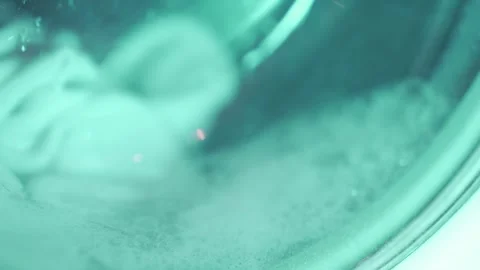 Washing Machine Interior: Soapy Clothes Swirling in Teal Water - 8bit Stock Footage 301560783