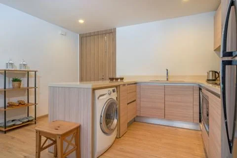 Washing machine in kitchen under counter top in villa and apartment Stock Photos