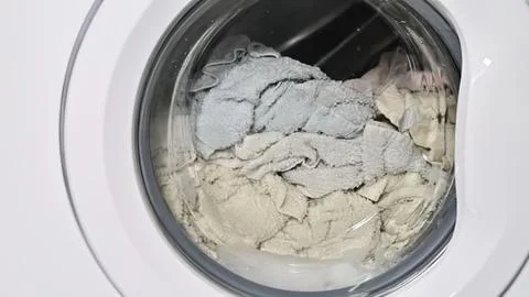 Washing machine with laundry inside during wash cycle Stock Photos