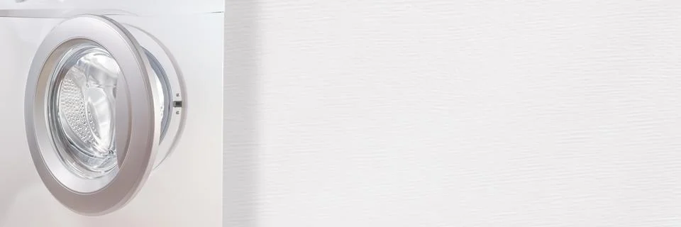Washing machine with open door against white wall template and background Stock-Fotos