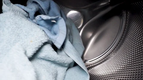 Washing machine in operation. Close-up clothes with water and foam rotate in the Stock Footage 129520545