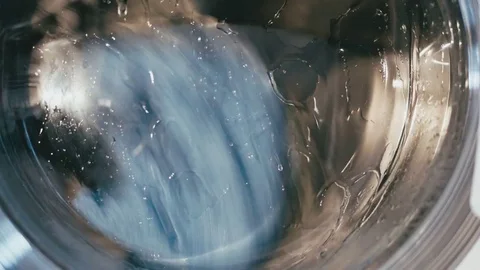 Washing machine progress filled with clothes macro shot Video stock 73912315