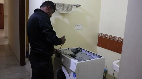 Washing machine repairing by a working professional expert man. Stock Footage 228397935