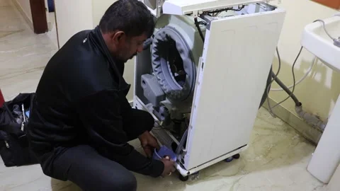 Washing machine repairing by a working professional expert man. Stock Footage 228398015