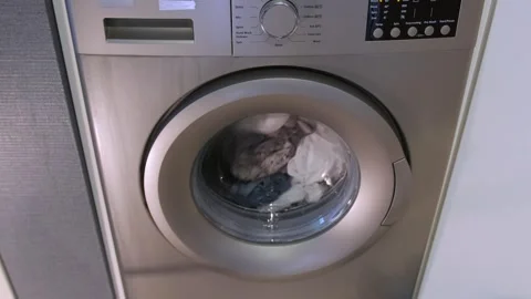 Washing machine rotating clothes front view, active cleaning cycle with water Stock-Footage 333649229