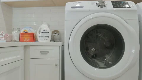 Washing Machine Running in an Empty White Laundry Room Stock Footage 155867445