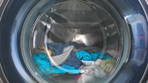 The washing machine washes dirty colored clothes. Stock Footage 255124757