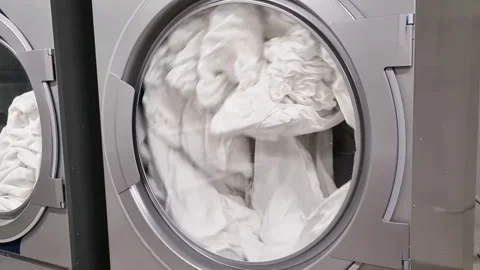 Washing machine washing clothes close up with clothes spinning inside. Stock Footage 240843935