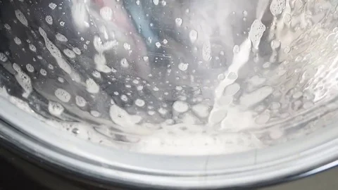 Washing machine washing clothes with laundry detergent Stock Footage