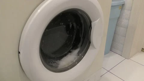 Washing machine washing clothes in the laundry room Stock Footage 173561271