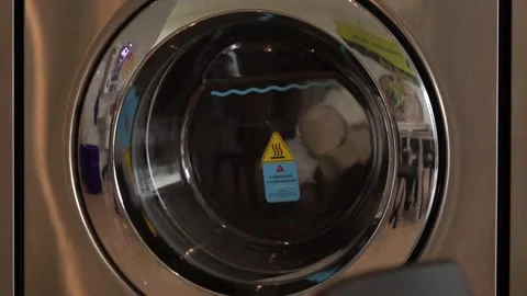 A washing machine with a yellow sticker on it that says "hot water" Stock Footage 289316404