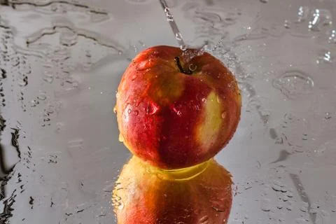 Washing one red apple with reflection and with splashes and drops of water Stock Photos