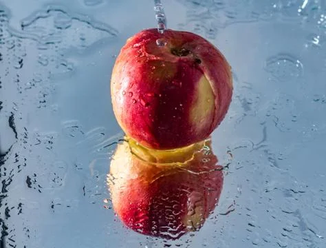 Washing one red apple with reflection and with splashes and drops of water Fotos Stock