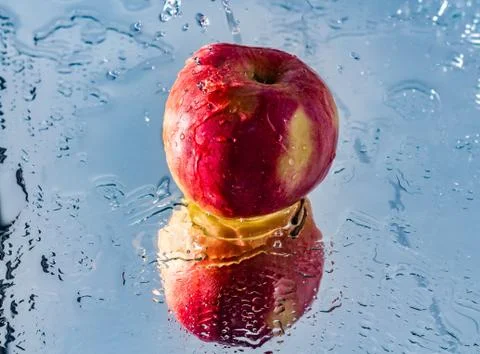 Washing one red apple with reflection and with splashes and drops of water Stock Photos