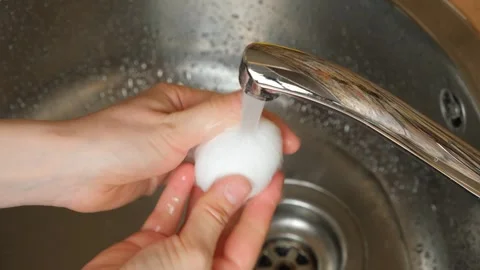 Washing raw chicken eggs in running water, hands close-up Stock Footage 337558599