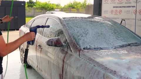 Washing a red car on a touchless car wash. Washing sedan car with foam and a Stock Footage 280118533