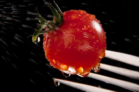 Washing a tomato on a fork Stock Photos