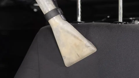 The washing vacuum cleaner pulls the dirt from the back of the seat. Video stock 247153004