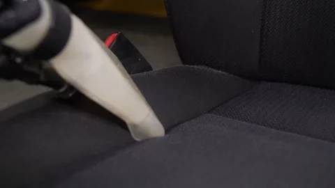 The washing vacuum cleaner pulls the dirt from of the seat. Video stock 248720765