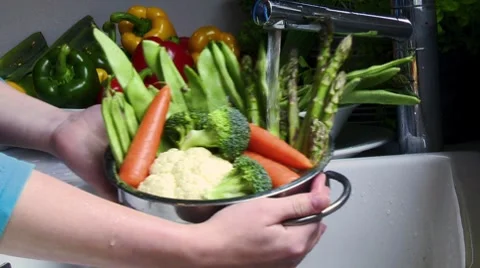 Washing vegetables in a colander under running water Stock Footage 8573443