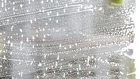 Washing the window with cleaning agent Stock Footage 240550200