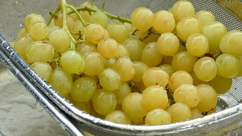 Washing yellow table grapes in a strainer closeup Stockbeeldmateriaal 119958021