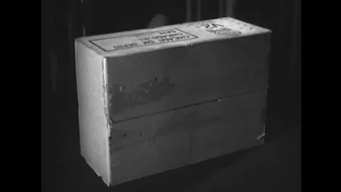 WASHINGTON DC - 1949 - A man opens a box of three individual C-4 ration boxes in Stock Footage 296693737