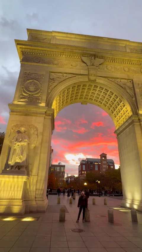 Washington Square Arch is lit up against the sunset at dusk in Greenwich Village Vidéo 342086004